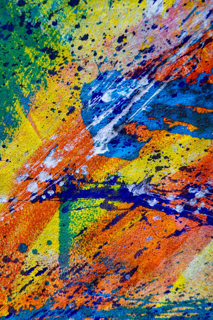 Colorful abstract art with vibrant paint splatters on canvas, showcasing creative expression.